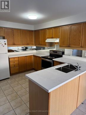 Brampton (Fletcher's Meadow) apartment for rent - A kitchen with wooden cabinets and a white counter.