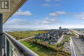 Grimsby (Grimsby Beach) condo for rent - A view from a balcony overlooking a residential area with a highway in the foreground.
