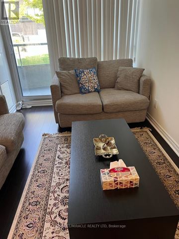 Toronto (Willowdale East) condo for rent - A living room with a couch, a coffee table, and a rug.