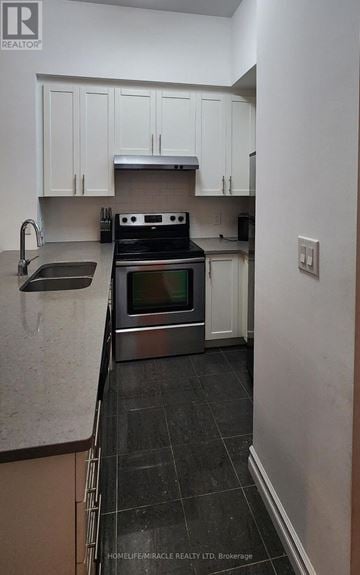 Toronto (Willowdale East) condo for rent - A kitchen with a stove top oven and a sink.