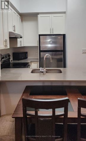 Toronto (Willowdale East) condo for rent - A kitchen with white cabinets and a stainless steel refrigerator.