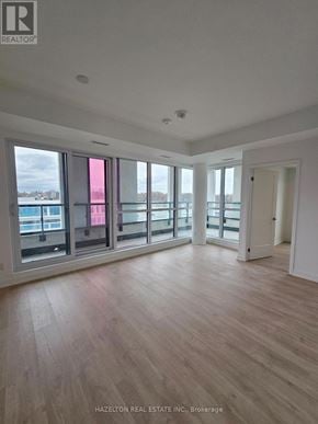 Toronto (Willowdale East) condo for rent - A room with wooden flooring and large windows overlooking a body of water.
