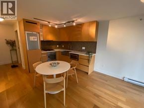 Vancouver apartment for rent - A kitchen with a table and chairs in the middle of the room.