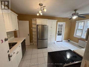 Toronto (Lawrence Park South) duplex for rent - A kitchen with white cabinets and a stainless steel refrigerator.