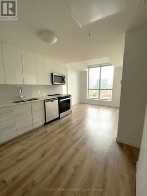 Kitchener condo for rent - A room with wooden flooring and a large window.