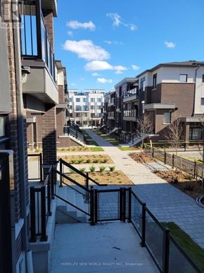Pickering (Duffin Heights) townhouse for rent - A view of a residential area with apartment buildings and a clear sky.