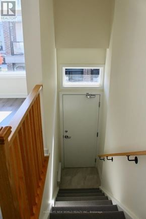 Pickering (Duffin Heights) townhouse for rent - A hallway with a white door and wooden stairs.