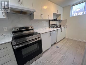 Georgina (Keswick South) apartment for rent - A kitchen with a black stove top oven and white cabinets.