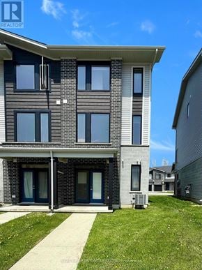 London East (East D) townhouse for rent - A modern two-story building with a balcony and a small garden in front.