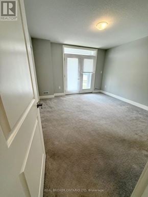 London East (East D) townhouse for rent - A carpeted room with a doorway leading to another room.