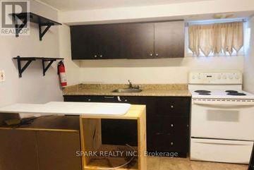 Brampton (Brampton East) apartment for rent - A kitchen with a white stove and black cabinets.