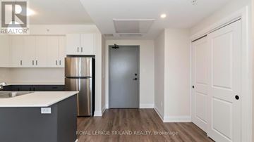 London North (North B) apartment for rent - A kitchen with white cabinets and a stainless steel refrigerator.