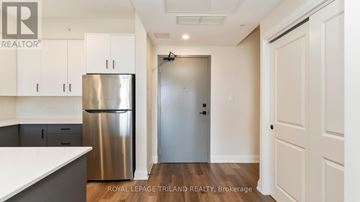 London North (North B) apartment for rent - A kitchen with white cabinets and a stainless steel refrigerator.