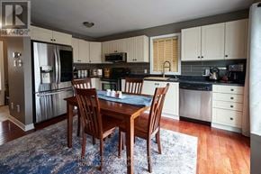 Ottawa apartment for rent - A kitchen with a table and chairs in front of a refrigerator.