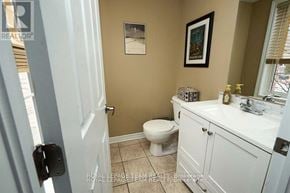 Ottawa apartment for rent - A bathroom with a toilet, sink, and a mirror.