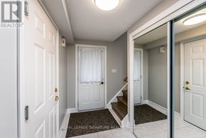 Barrie (Georgian Drive) apartment for rent - A hallway with a white door and a mirror on the wall.