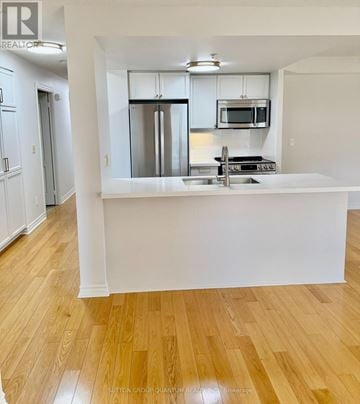Mississauga (City Centre) condo for rent - A kitchen with a white counter top and stainless steel appliances.