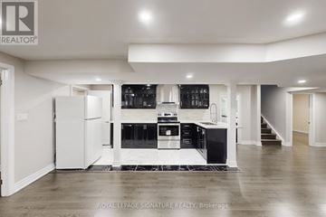 Brampton (Bram East) duplex for rent - A spacious kitchen with white cabinets and black appliances.