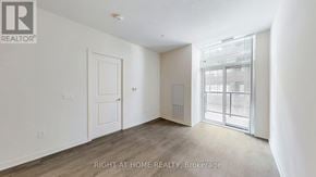 Toronto (Mimico) condo for rent - A room with a door and a window with a view of a building outside.