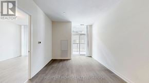 Toronto (Mimico) condo for rent - A spacious room with a door leading to another room.