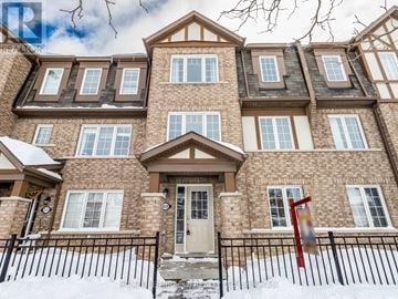 Brampton (Northwest Brampton) townhouse for rent - A large house with a brown and beige exterior and a black fence.