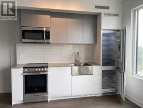 Toronto (South Parkdale) condo for rent - A modern kitchen with a stainless steel oven and microwave.