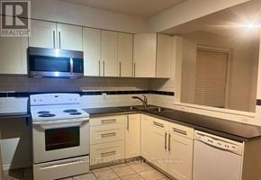 Toronto (Corso Italia-Davenport) apartment for rent - A kitchen with white cabinets and a black countertop.
