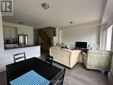 Thorold (Rolling Meadows) townhouse for rent - A living room with a black table and a couch.