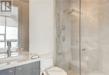 Toronto (Waterfront Communities) condo for rent - A modern bathroom with a walk-in shower and a double sink vanity.