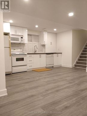 Toronto (Woodbine-Lumsden) apartment for rent - A modern kitchen with white cabinets and a stainless steel refrigerator.