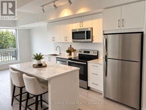 Toronto (Humber Heights) condo for rent - A modern kitchen with stainless steel appliances and white cabinets.