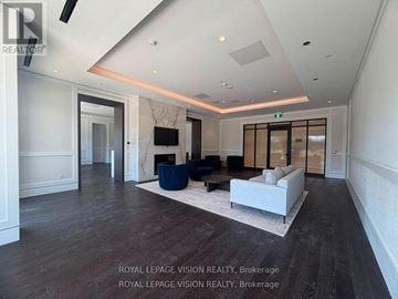 Toronto (Humber Heights) condo for rent - A spacious living room with a white sofa and a television.