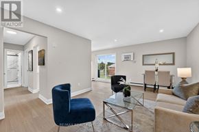 St. Catharines (Secord Woods) multi-family for rent - A living room with a blue chair and a glass coffee table.