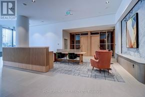 Mississauga (City Centre) condo for rent - A reception area with a wooden desk and chairs.