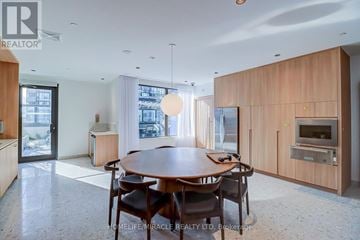 Mississauga (City Centre) condo for rent - A modern dining room with a wooden table and chairs.