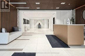 Toronto (Willowdale East) condo for rent - A modern office lobby with a reception desk and a long hallway.