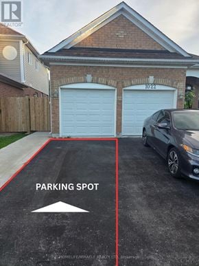 Oshawa (Pinecrest) apartment for rent - A parking spot is marked on a driveway in front of a house.