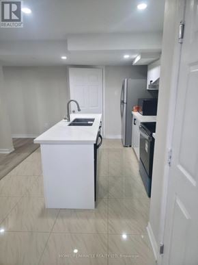 Oshawa (Pinecrest) apartment for rent - A white kitchen with a sink and a refrigerator.