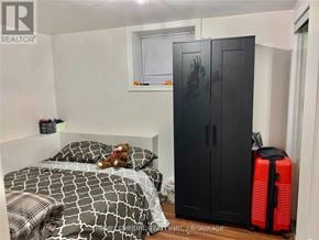 Toronto (Willowridge-Martingrove-Richview) apartment for rent - A bedroom with a bed, a wardrobe, and a suitcase.