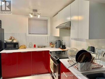 Toronto (Willowridge-Martingrove-Richview) apartment for rent - A kitchen with red cabinets and a white countertop.
