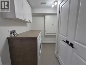 Hamilton apartment for rent - A small kitchen with white cabinets and a wooden counter.