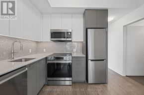 Kitchener condo for rent - A modern kitchen with stainless steel appliances and white cabinets.