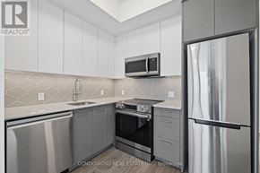 Kitchener condo for rent - A kitchen with a refrigerator, oven, and microwave.