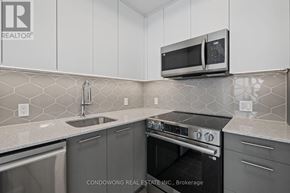 Kitchener condo for rent - A modern kitchen with a stainless steel oven and microwave.