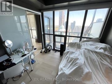 Toronto (Church-Yonge Corridor) condo for rent - A bedroom with a large bed and a desk with a chair.