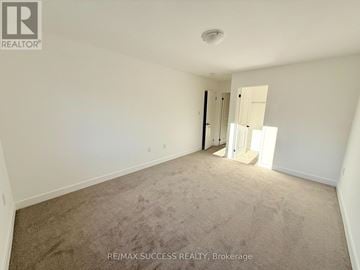 Barrie apartment for rent - A room with a carpeted floor and a doorway leading to another room.