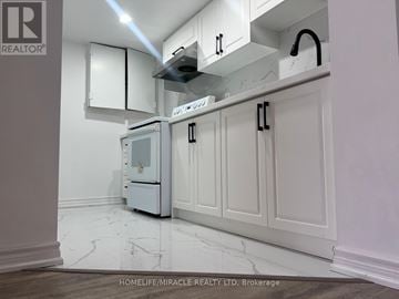 Toronto (Ionview) apartment for rent - A kitchen with white cabinets and a white fridge.