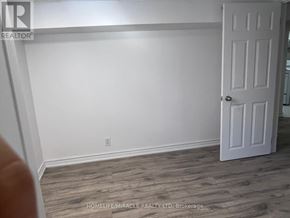 Toronto (Ionview) apartment for rent - A white door is on the right side of a room with a wooden floor.