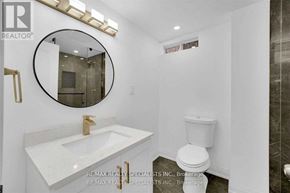 Mississauga (Lisgar) apartment for rent - A white bathroom with a round mirror and a toilet.
