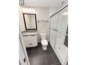 Coquitlam apartment for rent - A bathroom with a toilet, sink, mirror, and shower.